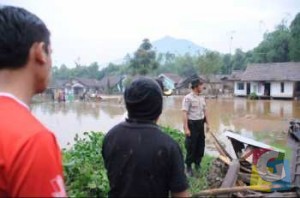Sejumlah petugas dan warga saat menyaksikan banjir bandang yang menerjang perkampungan di kecamatan Cikajang Garut, Selasa (9/12/2014). foto jmb