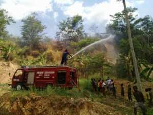Petugas Pemadam Kebakaran berusaha memadamkan api pada kebakaran lahan agar tidak merembet keperkampungan warga, foto Hermanto
