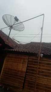 Salah satu antena parabola milik warga yang terhempat angin kencang saat hujan deras, foto Hermanto