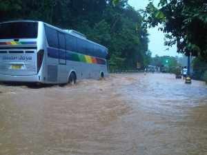 Sebuah mobil bus terlihat saat berusaha melintasi genangan banjir di jalan siliwangi Kota Banjar, foto Hermanto