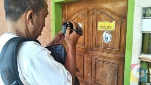Seorang wartawan mengabadikan sticker bergambar Dimas Kanjeng Taat Pribadi dipintu rumah Rukoyah warga Purwakarta, foto Deni