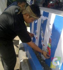 Calon Walikota Tasik nomor urut 1 Diky Chandra saat mencabuti poster dirinya karena dipasang di Zona terlarang, foto dok